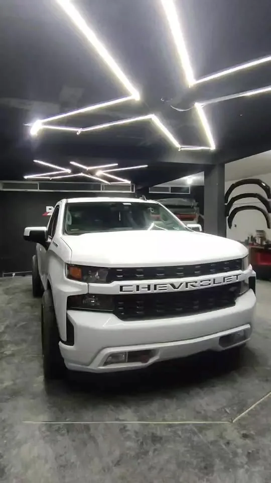 Chevrolet Silverado blanca bajo las luces del taller de Detail X